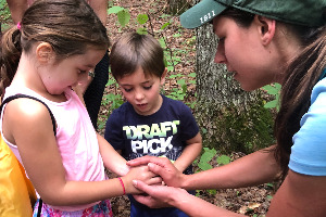 Kids hold a frog found during a hike